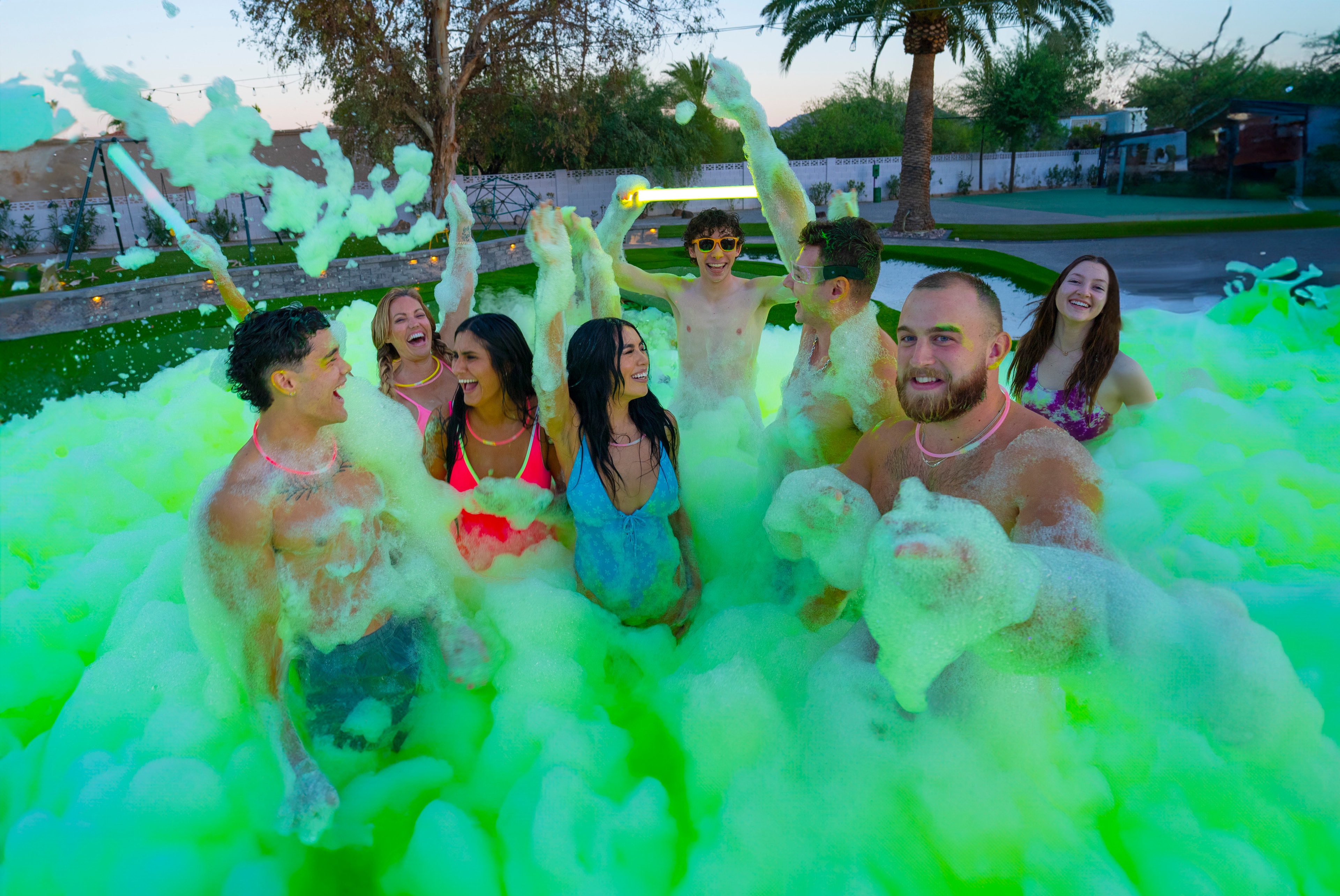 Group celebrating in neon green foam party