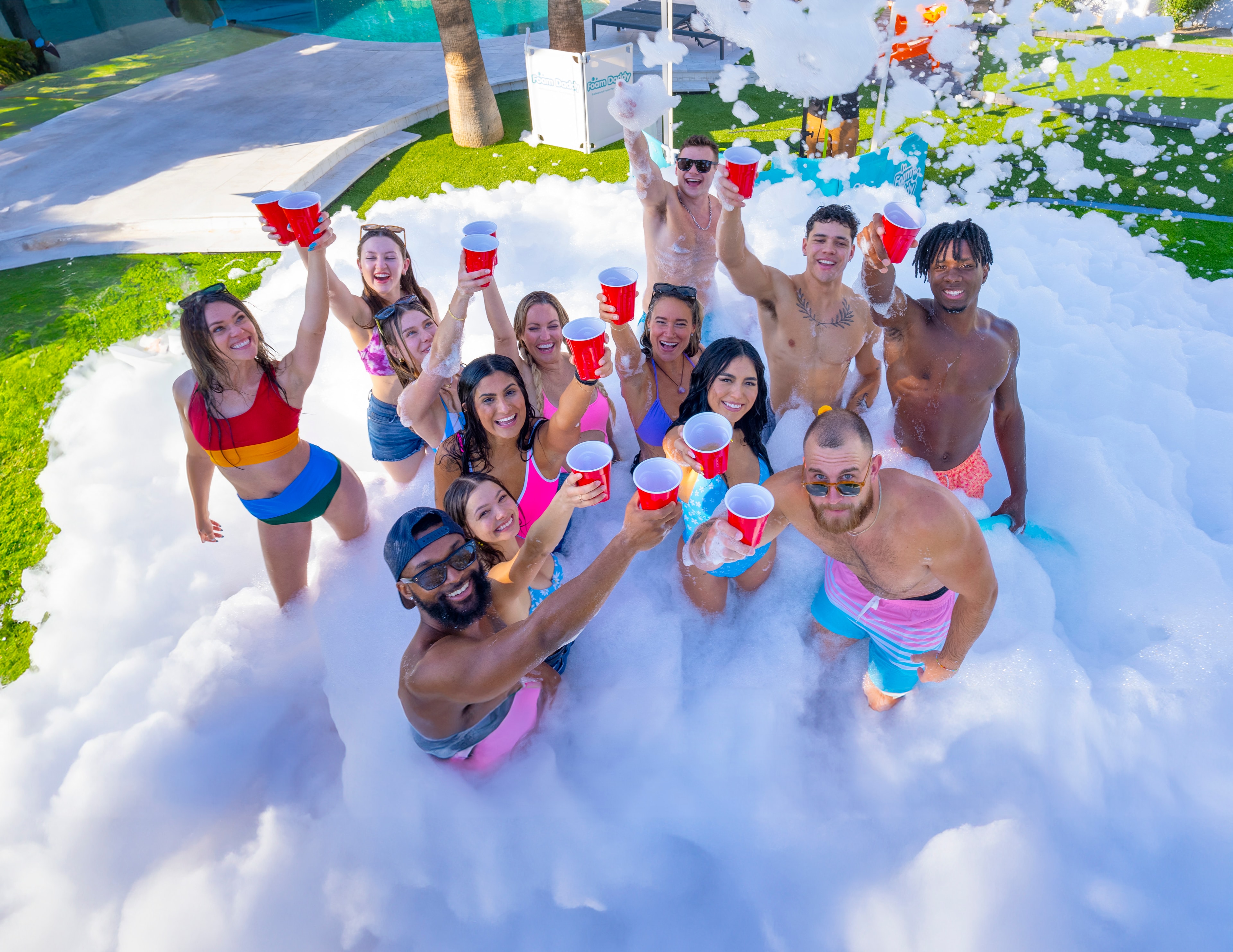 College party group toasting with red cups in foam
