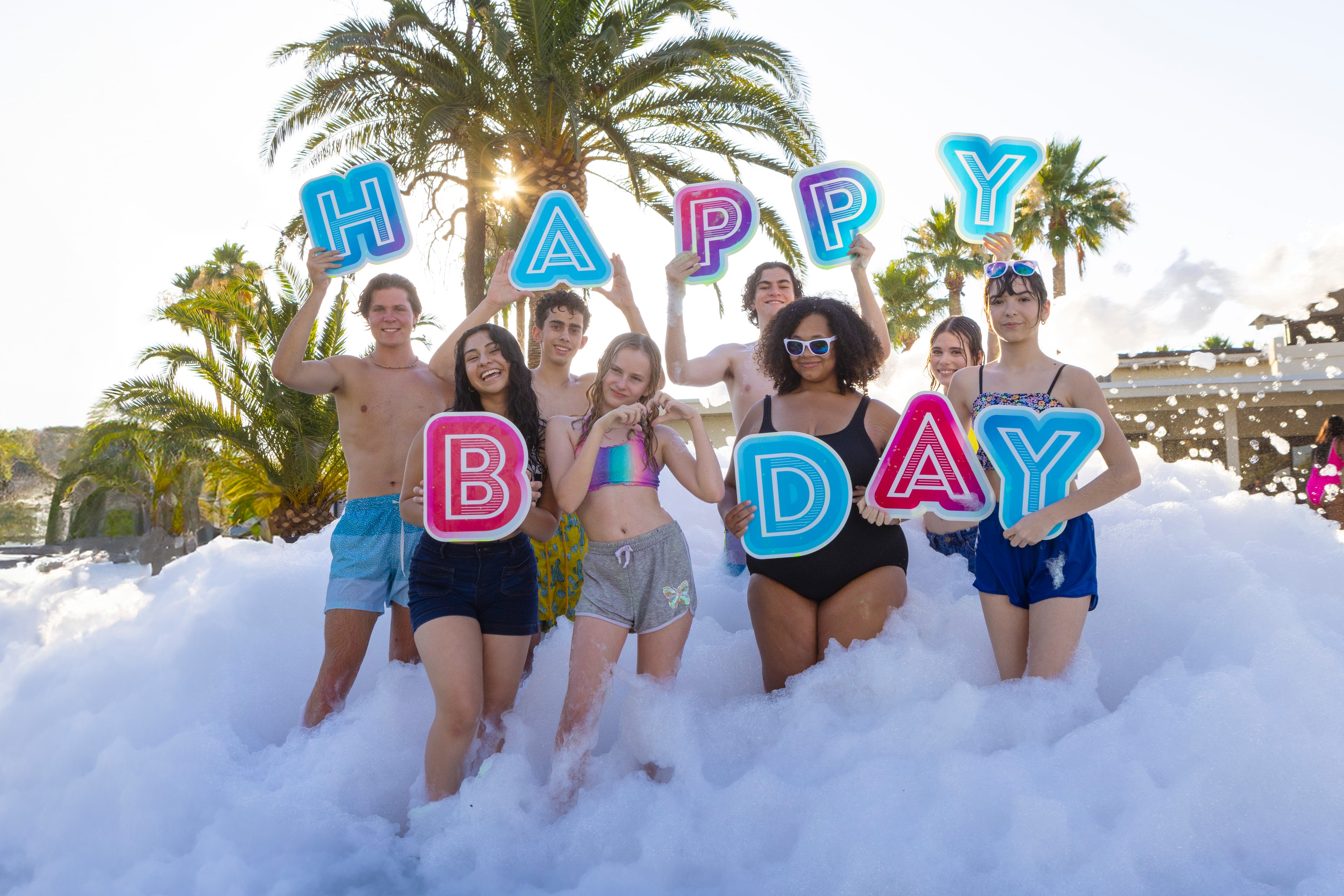 Teens holding Happy Birthday signs in foam